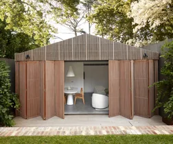 A modern timber-clad pool house which has been designed as a studio.