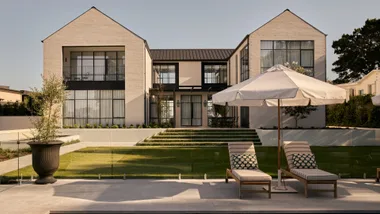 H-shaped home with paved pool area and manicured landscaping.