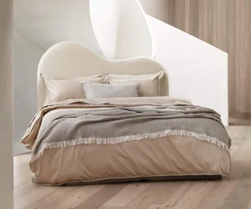Neutral bed with a curved boucle bedhead