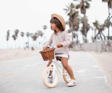 girl riding balance bike outside