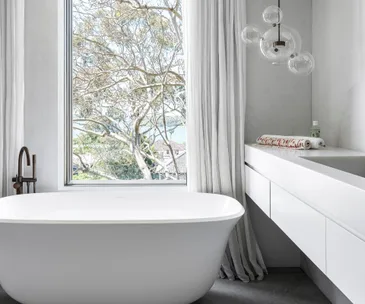 White bathroom with window overlooking harbour