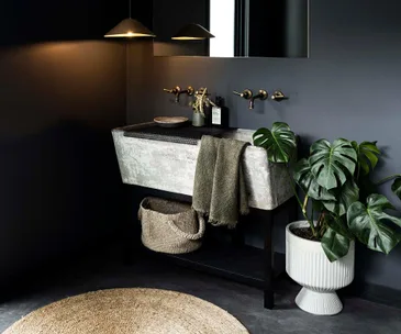 Vintage concrete trough sink in a black, modern farmhouse laundry