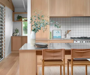A kitchen with stainless steel benchtops and timber cabinetry