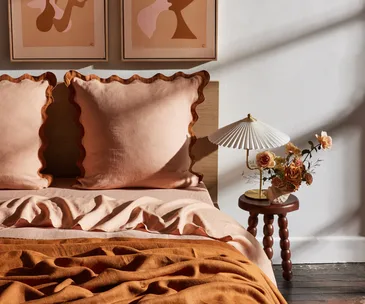 A bed with terracotta-coloured sheets from Bed Threads