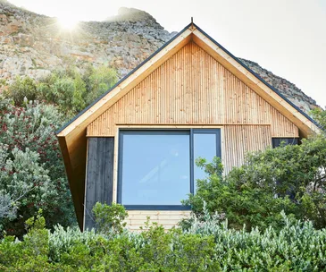 A timber cabin surrounded by greenery