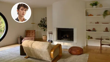 A beige living room in Troye Sivan's Los Angeles home for sale with a man in a round frame with brunette hair