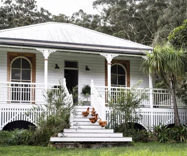 A renovated post office with a country verandah and chickens stood upon the steps