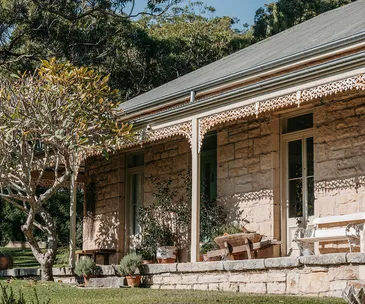 The exterior of a historic sandstone cottage