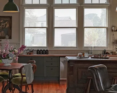 A kitchen with a large curved window and pendant lights