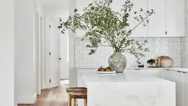 white kitchen with large stone island bench